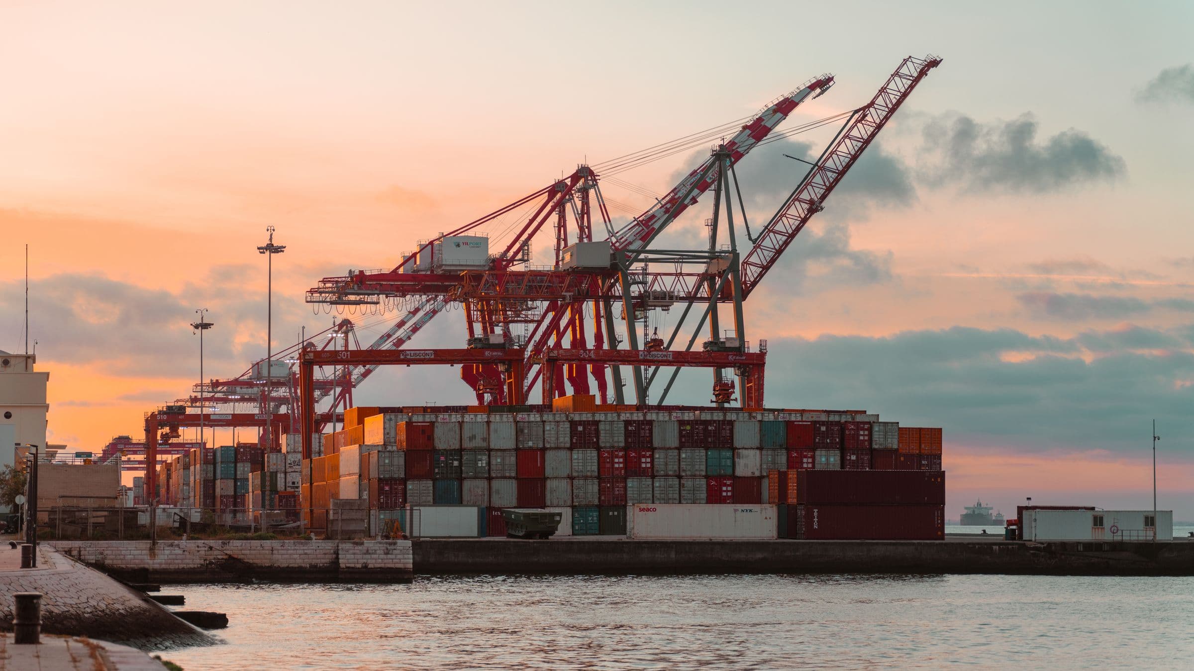 Container cranes at a terminal at sunset